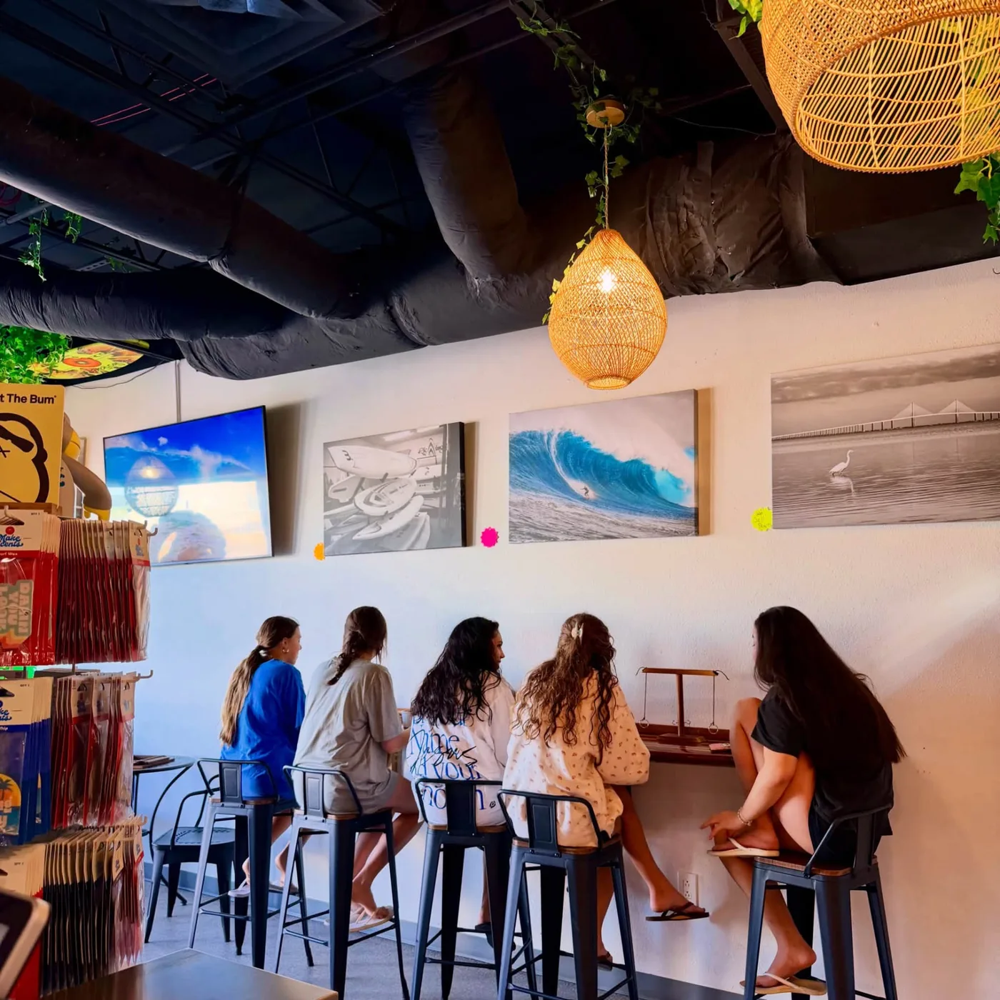 Guests at the window bar inside AMI FroYo with surf photography and beach retail