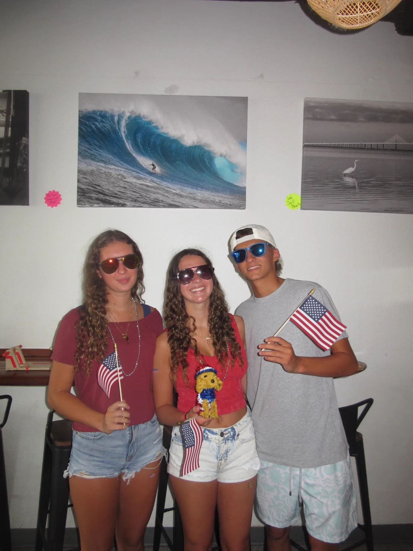 Three friends with flags and sunnies by the surf print inside AMI FroYo